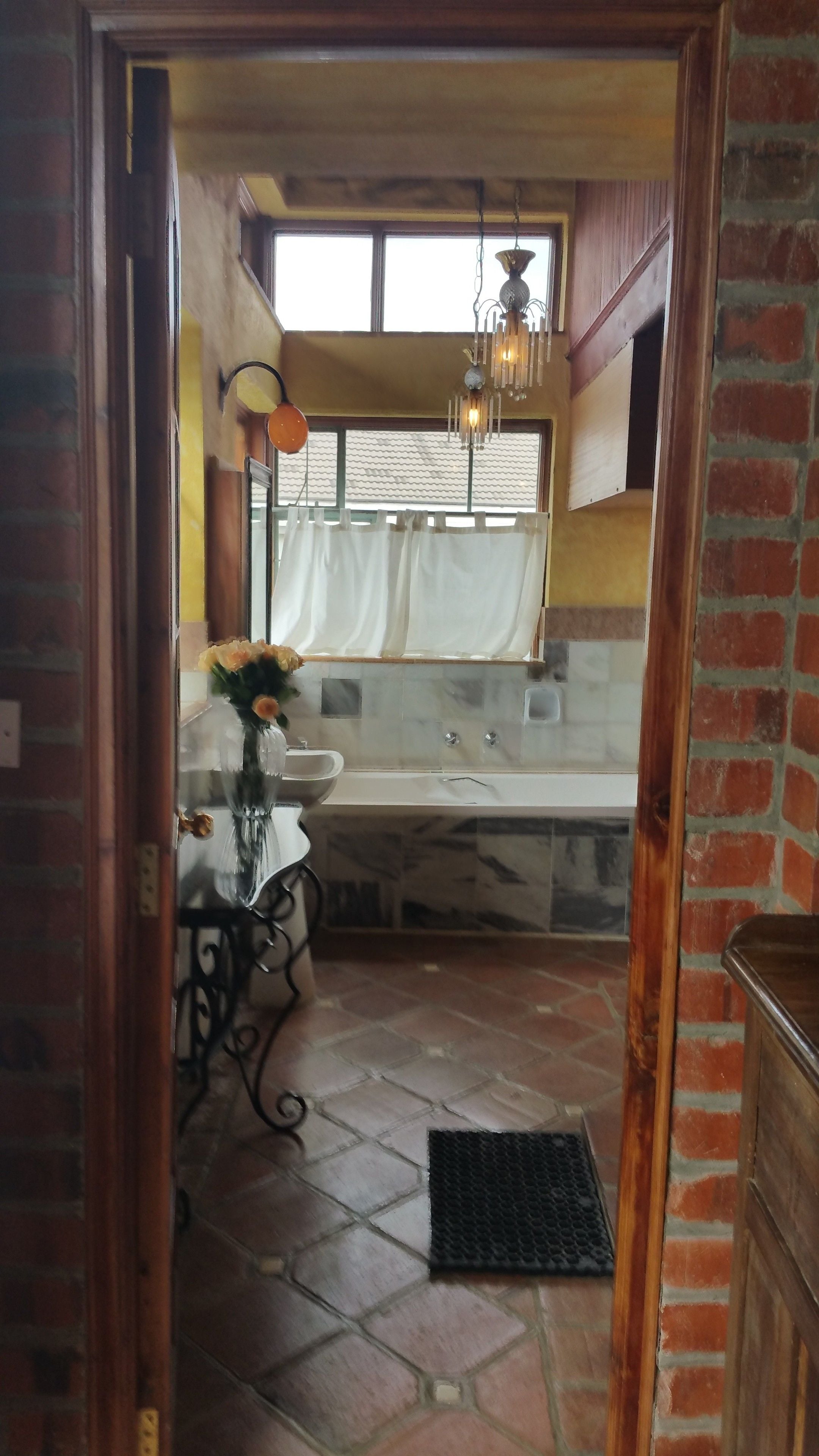 Ein Badezimmer mit Waschbecken, Spiegel und einer Pendelleuchte.