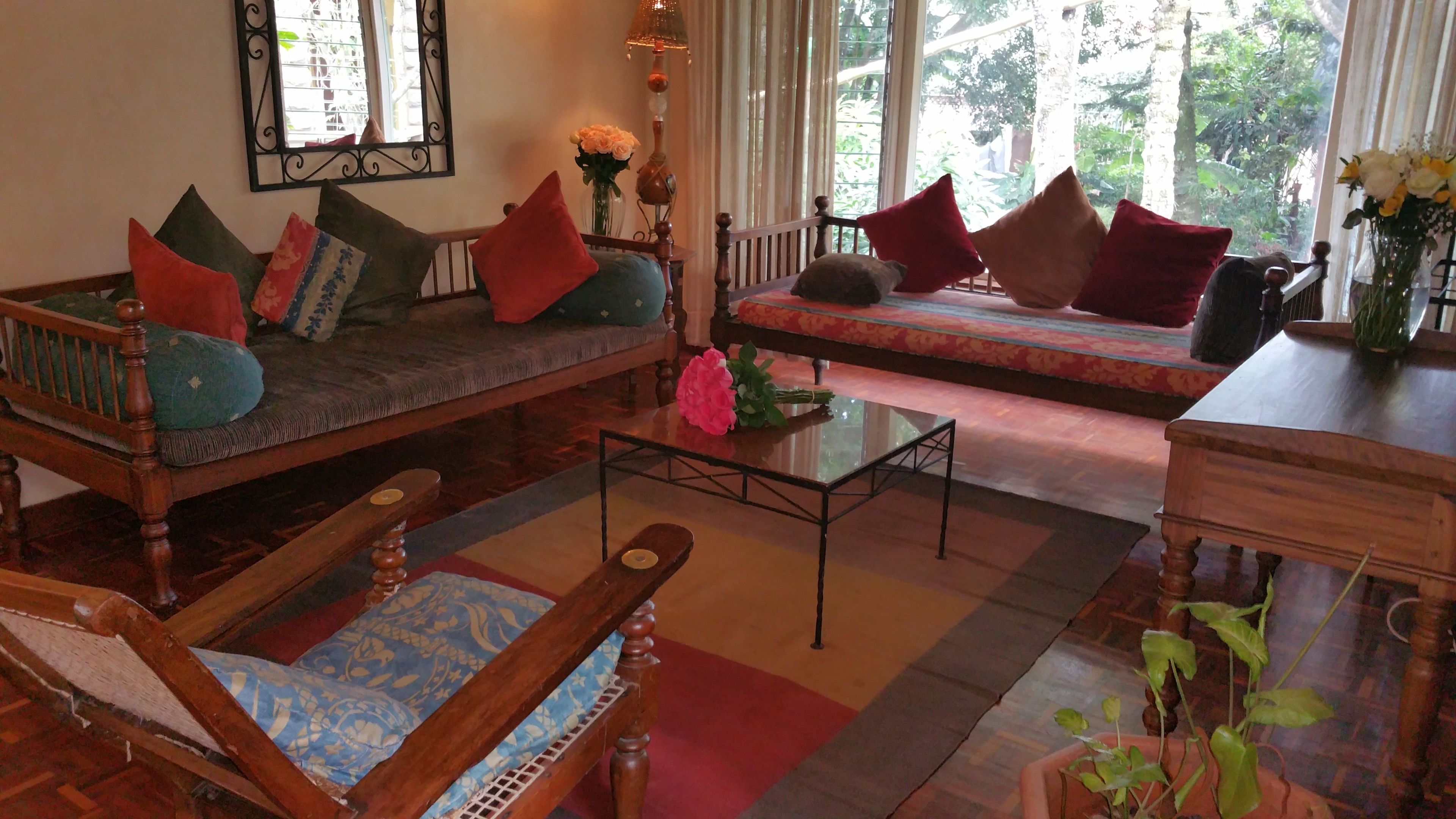 A cozy living room with a sofa, armchair, and a small table with a vase of flowers.