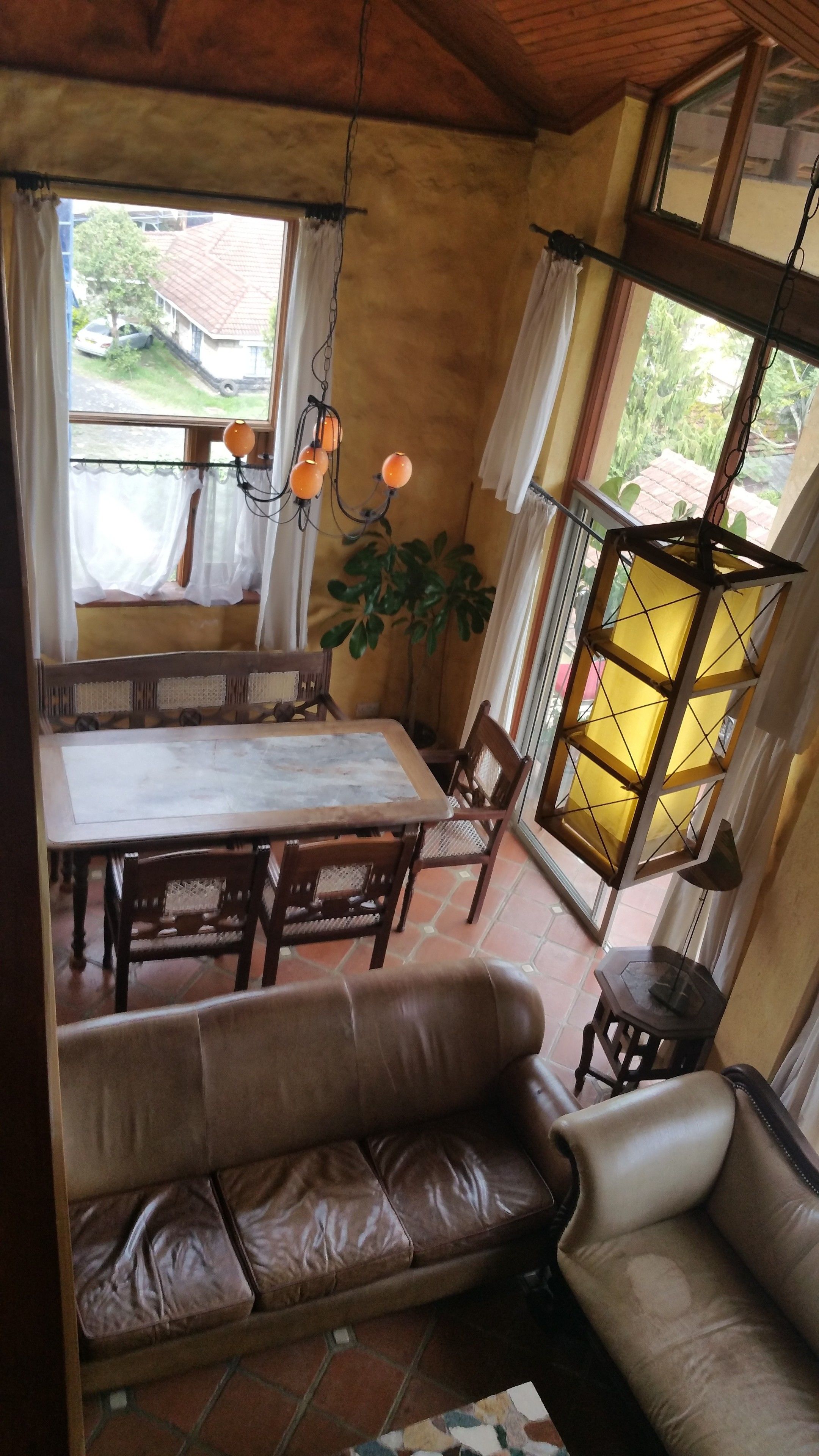 Un comedor acogedor con una mesa, sillas, un sofá y una planta en maceta.
