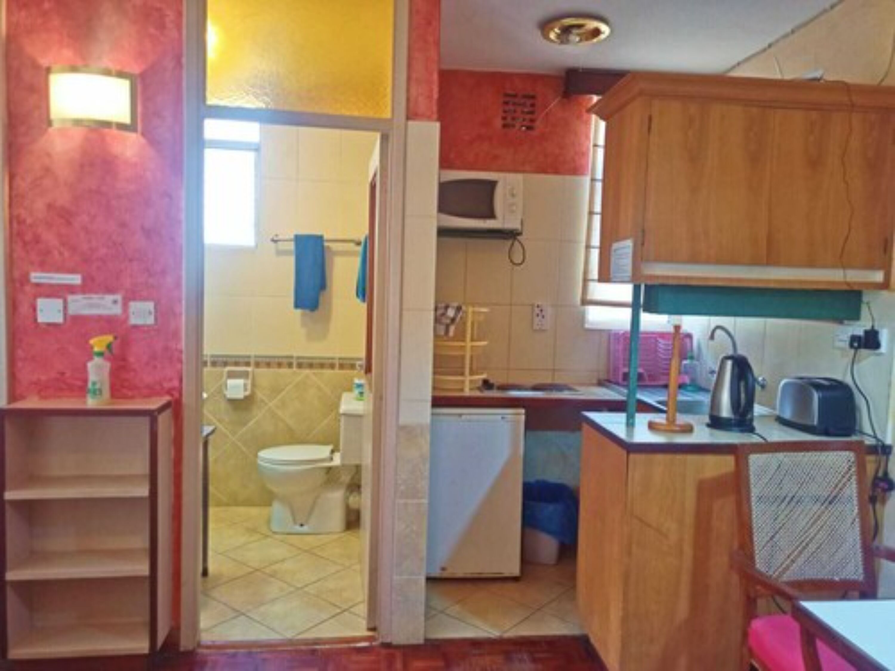 A compact kitchen with a microwave, toaster, and sink.