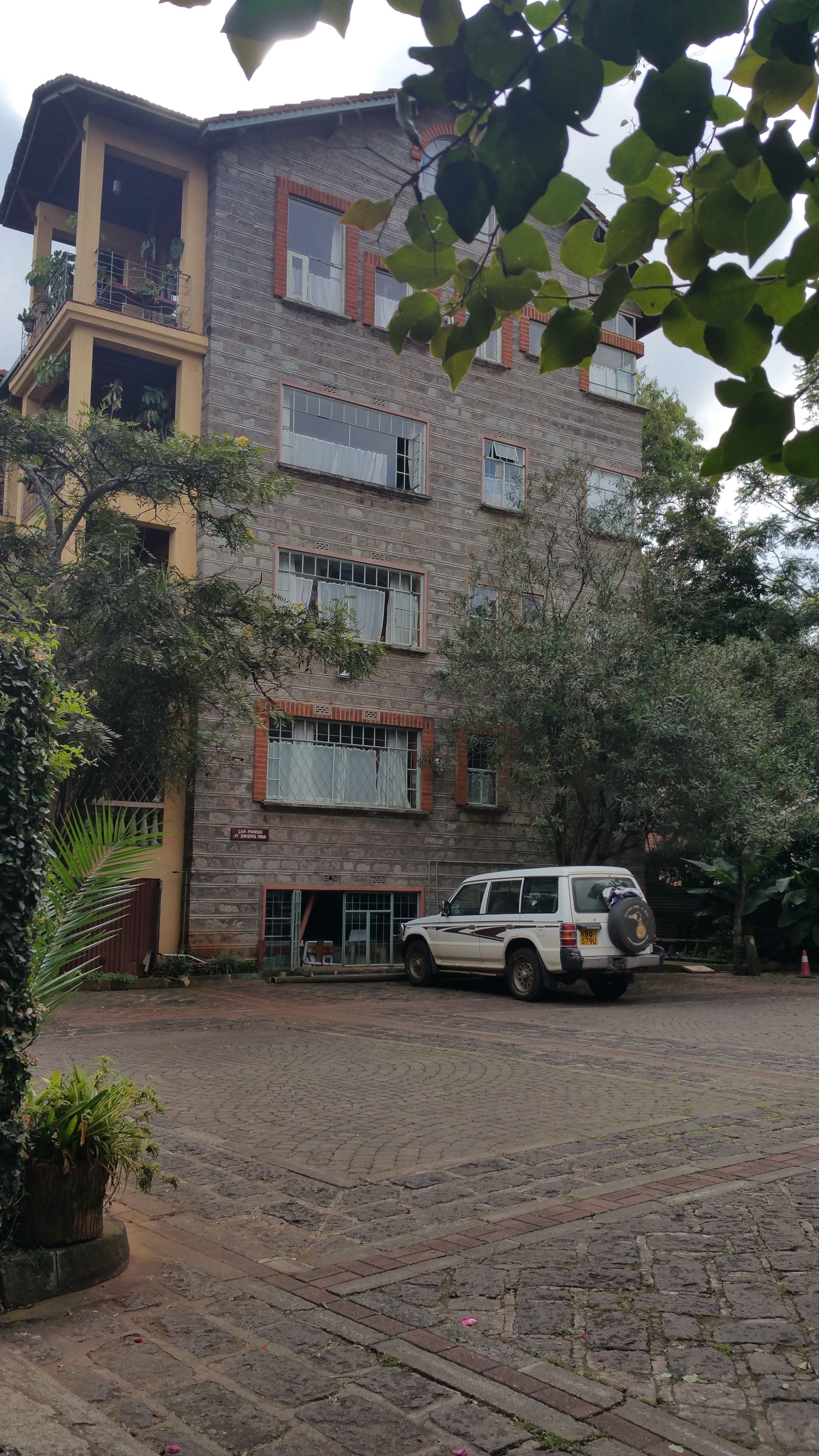 A multi-story building with a car parked in front.