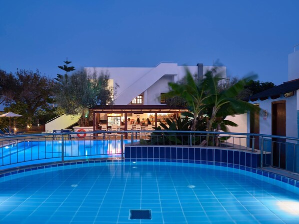 Alberca al aire libre, sombrillas en la alberca y camastros 