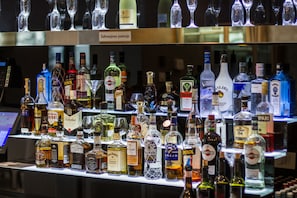 A bar area with various liquor bottles and glasses.
