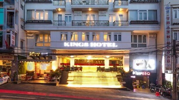 Een meerlaags hotel met een opvallend bord waarop 