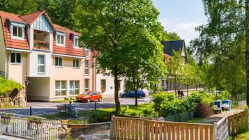 A residential area with multi-story buildings, a small garden, and a pedestrian pathway.