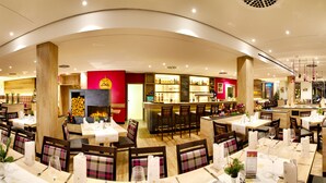 A restaurant with multiple dining areas, a bar, and a fireplace. - Hotel Waldmühle (Zella-Mehlis)