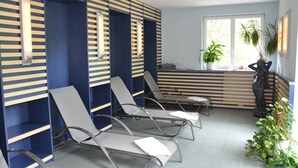 A waiting area with lounge chairs, a reception desk, and a large window with plants. - Hotel Waldm ühle (Zella-Mehlis)