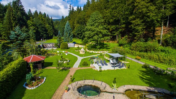A lush garden with a pond, seating areas, and a gazebo. - Hotel Waldmühle (Zella-Mehlis)