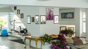 Amplia sala de estar con escalera, equipo de ejercicio y variada decoración de pared.