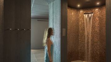 Un baño moderno con pared de mosaicos, zona de ducha y picaporte visible.