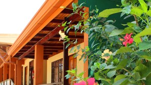 A wooden staircase leading to a covered porch with a tiled floor. - Hotel Alkamar (Cóbano)