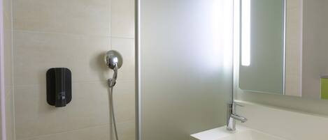 A bathroom with a shower, a sink, and a mirror.