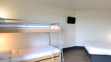 Ein Stockbett mit einer Leiter, ein Einzelbett, ein Flachbildfernseher an der Wand und Holzboden.