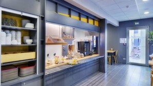 A modern kitchen area with a counter, shelves with dishes, and a coffee machine. - B&B HOTEL Marseille Les ports (Marseille)