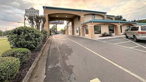 A Budget Inn with a parking lot and a sign reading "Marines Fight to Win". - Budget Inn (Northport)