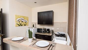 Apartamento, 2 quartos | Cozinha americana privada | Geladeira, micro-ondas, talheres/pratos/utensílios de cozinha
