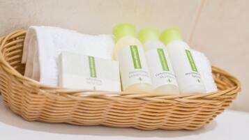 A wicker basket containing a white towel, three bottles of skincare products, and a box labeled "nourishing conditioner".