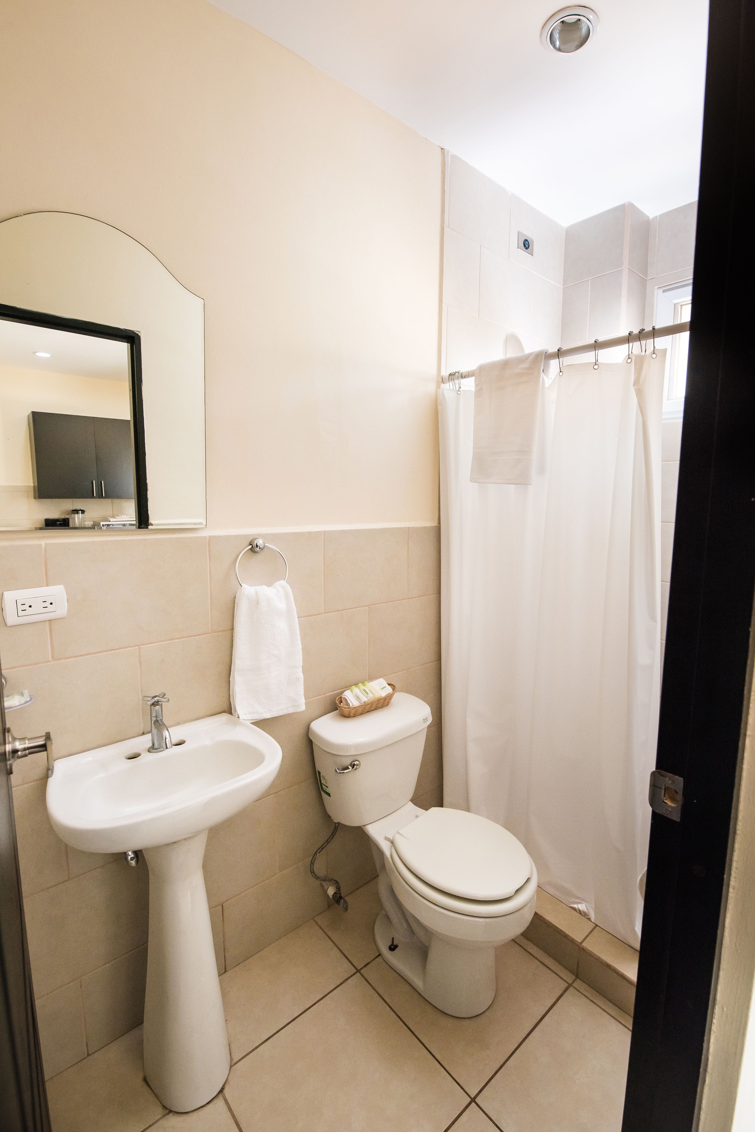 Une salle de bain équipée d’un lavabo, de toilettes et d’un rideau de douche.