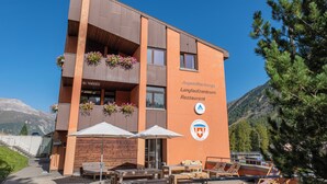 Een modern gebouw met een bord waarop 'Jugendherberge Langlaufzentrum Restaurant' staat.