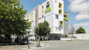 A modern B&B hotel with a white facade and green signage.