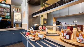 A breakfast buffet setup with a variety of food items and condiments.