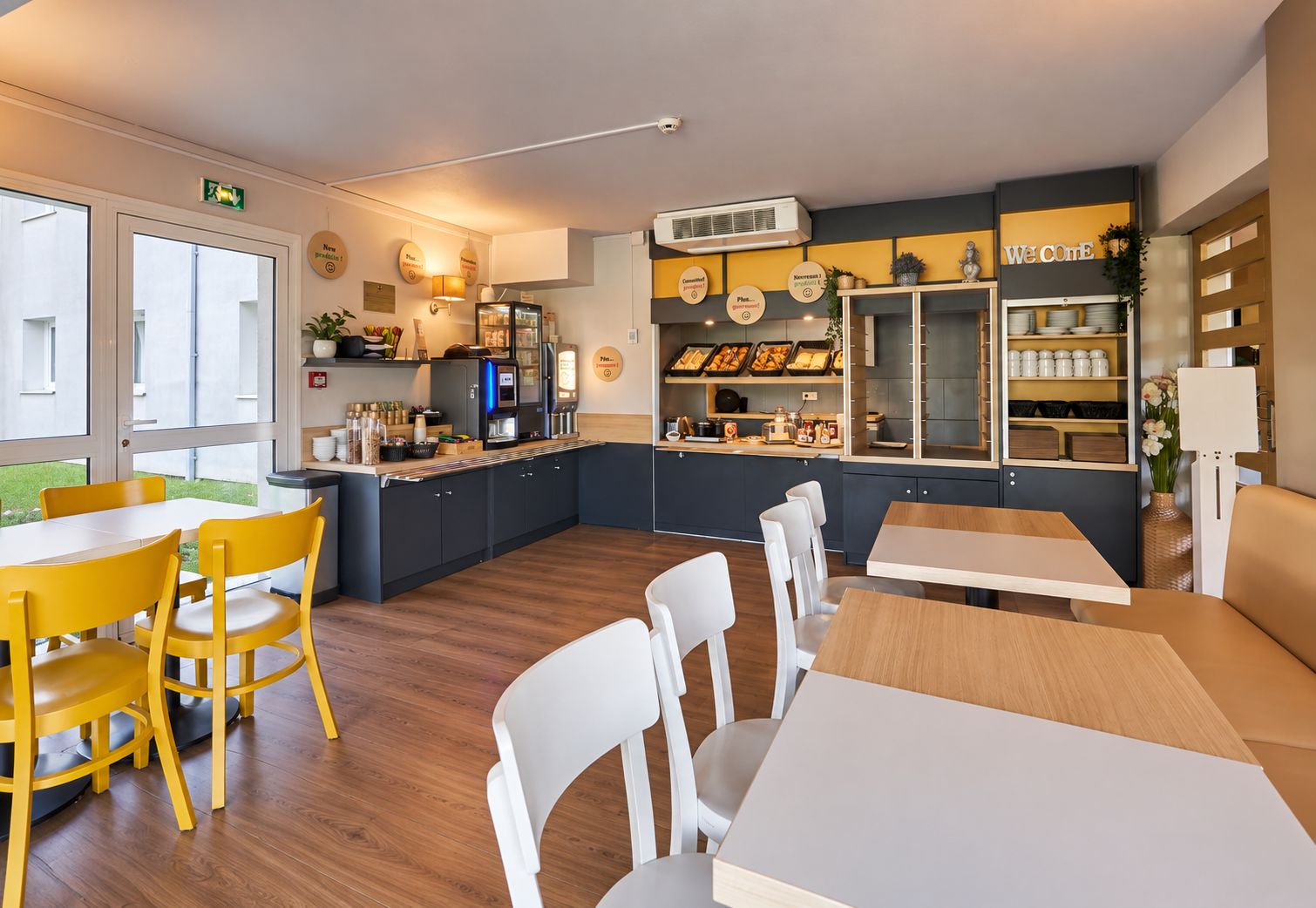Une cuisine moderne équipée d’une machine à café, d’un four encastré et de divers ustensiles de cuisine rangés sur des étagères.