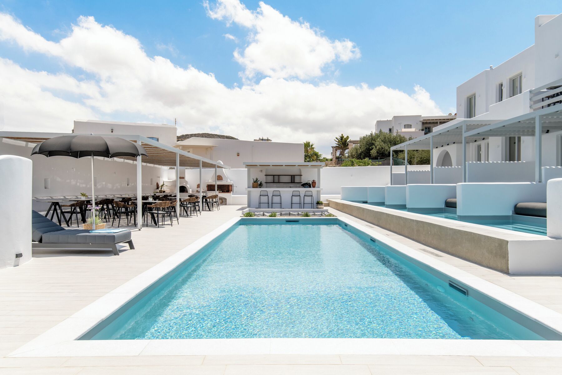 Una piscina al aire libre de temporada, sombrillas