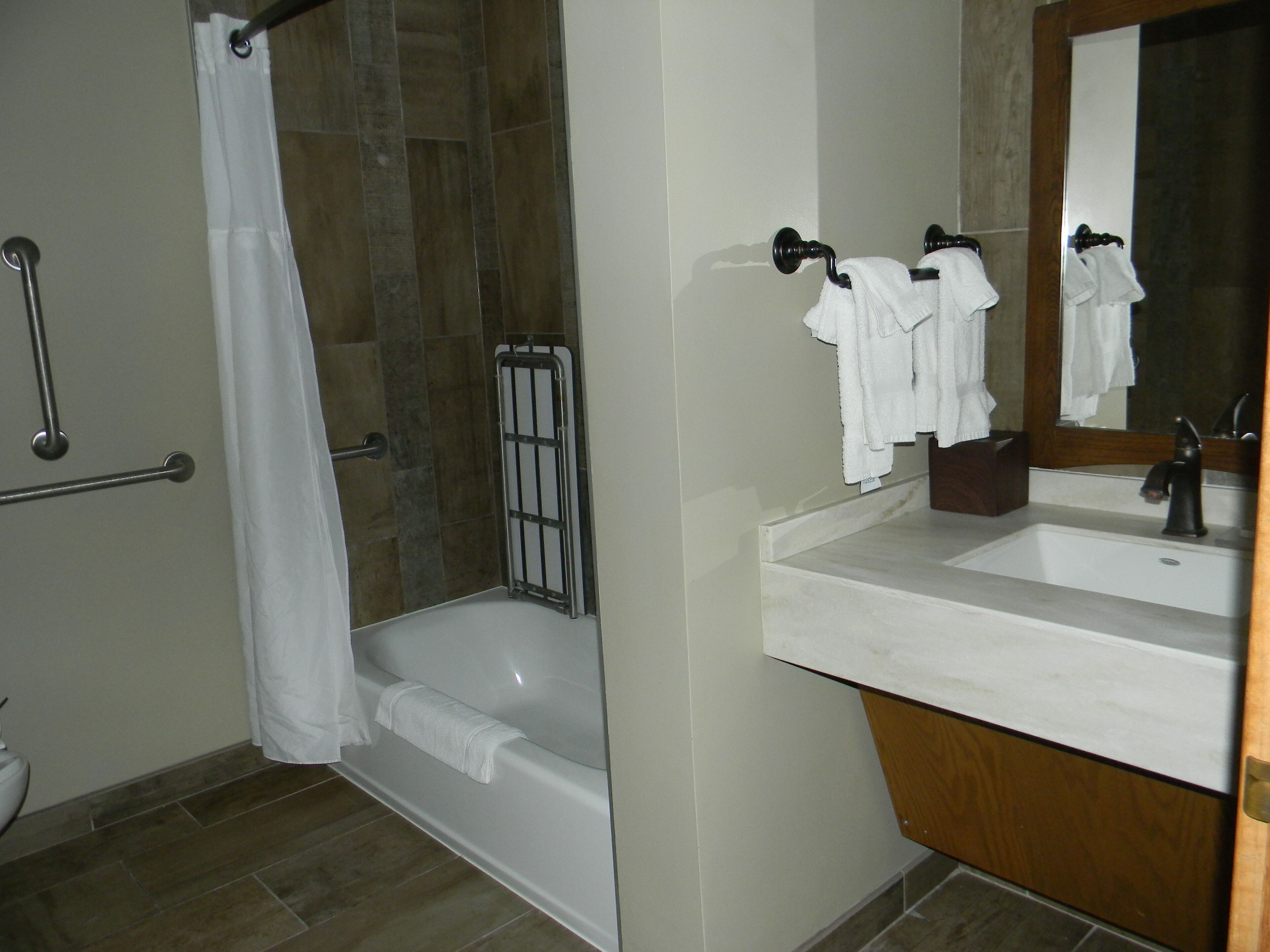 Une salle de bain avec une douche, un lavabo et un miroir.