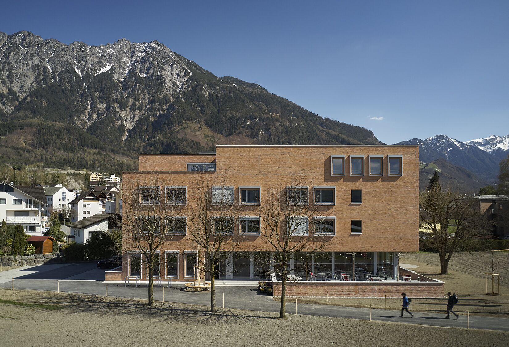 Un bâtiment moderne à deux étages, doté d’une façade en briques, de nombreuses fenêtres et d’un toit plat.