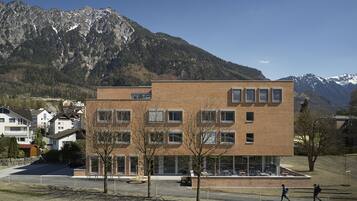 Un bâtiment moderne à deux étages, doté d’une façade en briques, de nombreuses fenêtres et d’un toit plat.
