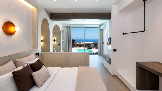 Ein modernes Schlafzimmer mit großem Bett, Blick auf Pool und Außenbereich und minimalistischem Design.