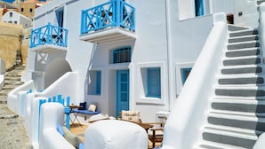A white building with blue accents, including balconies and windows. - Genesis Cave Houses (Santorini)