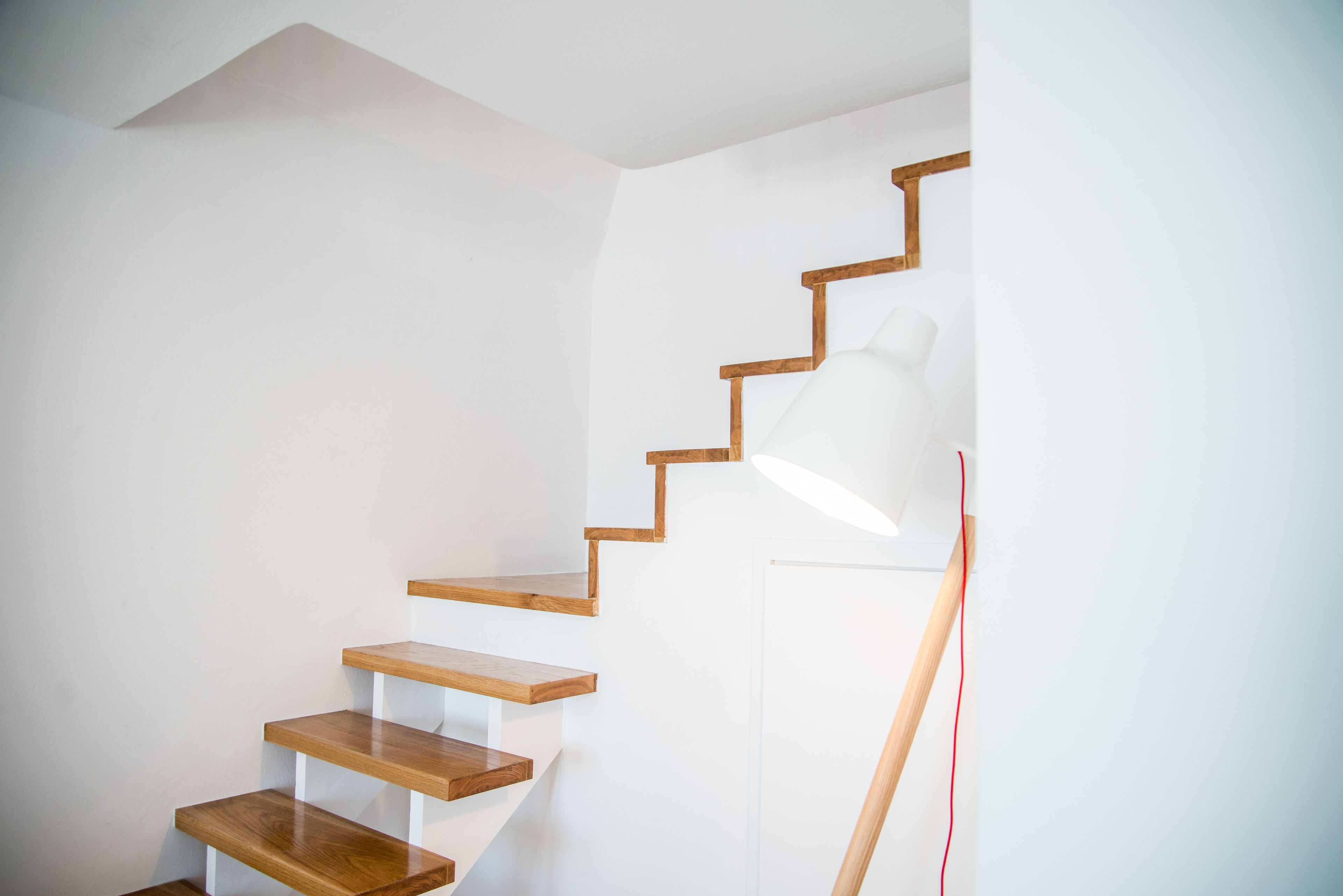 A staircase with wooden steps and a white wall.