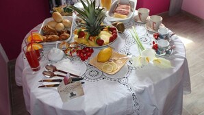 Una mesa de desayuno con diversos alimentos, bebidas y utensilios.