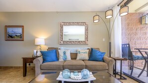 A living room with a sofa, a coffee table with decorative items, a lamp, and a framed picture on the wall.