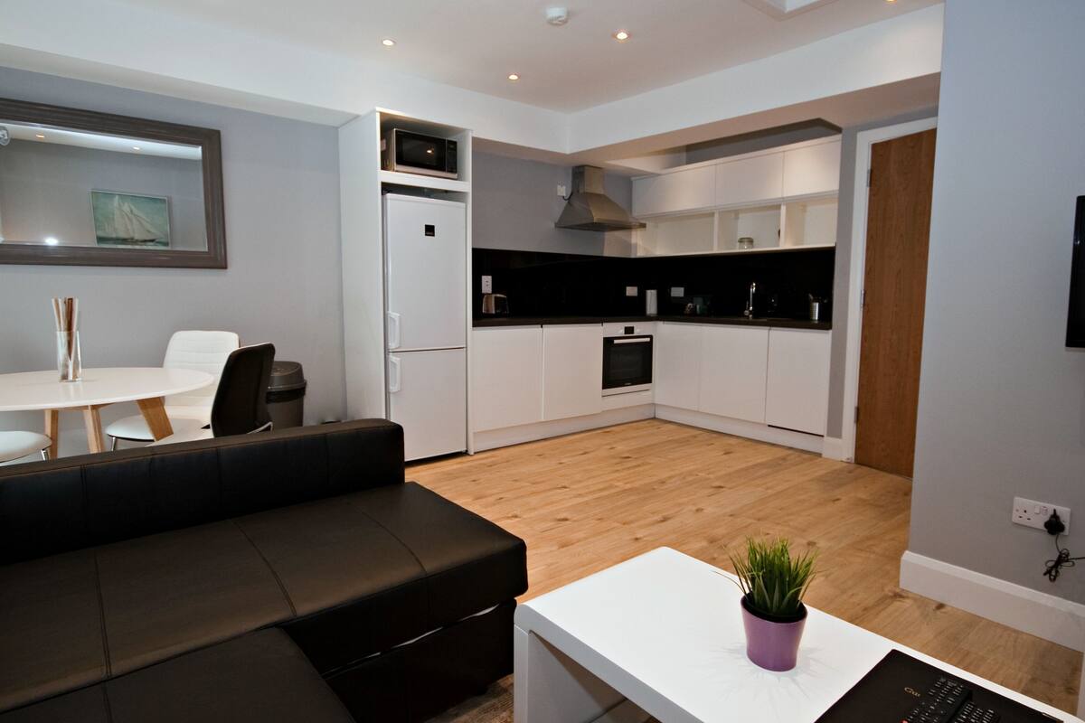 Um apartamento moderno com sala de estar, área de jantar e cozinha.