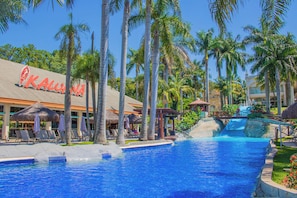 A resort pool area with palm trees, lounge chairs, and a waterfall feature. - Mavsa Resort Convention & SPA - All inclusive (Cesario Lange)