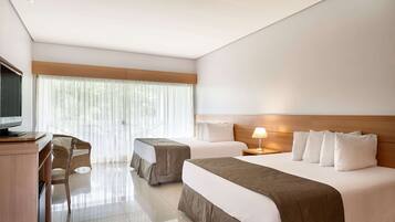 Quarto de hotel com duas camas, uma escrivaninha e uma televisão.