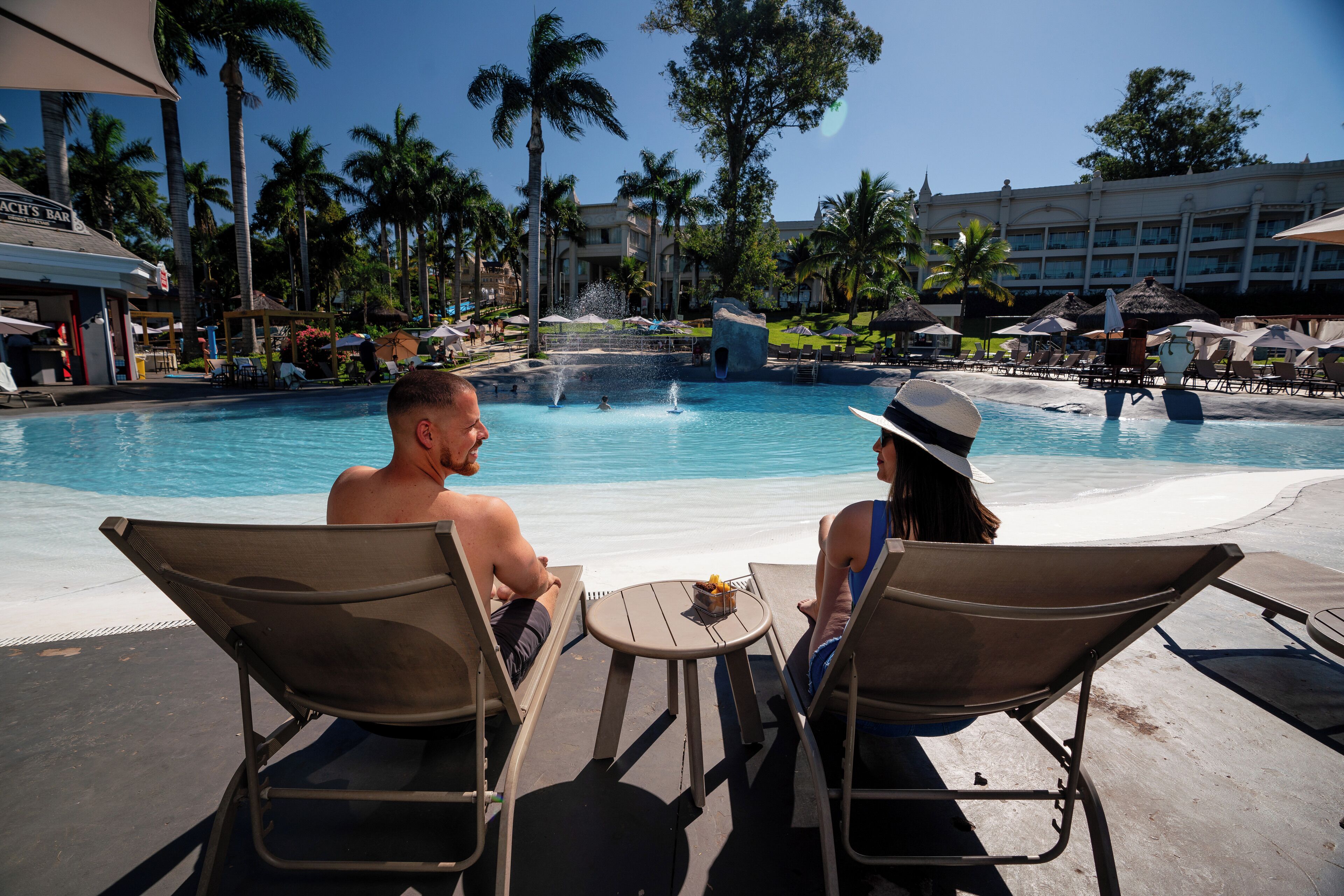 A poolside area with lounge chairs and a bar.