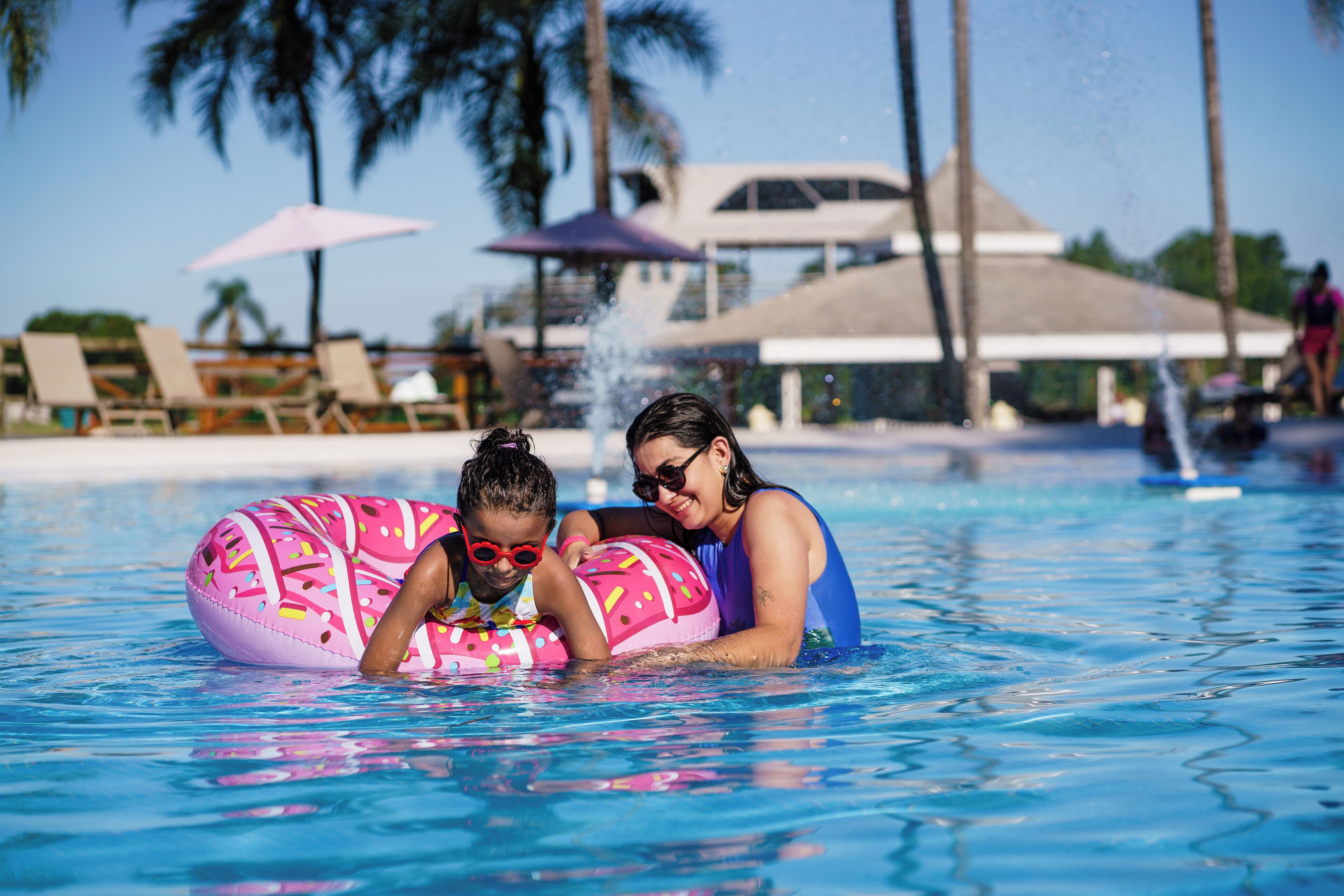 A swimming pool with lounge chairs and umbrellas.