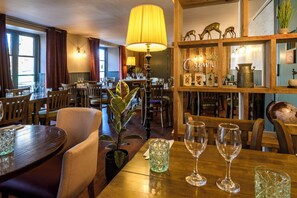 A restaurant with wooden furniture, a large yellow lamp, and a sign reading 'Crown Hotel.' - The Crown Hotel (Lynton)