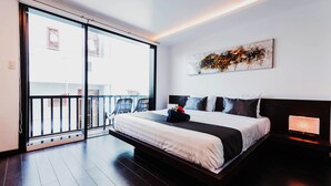Un dormitorio moderno con una cama grande, un ventanal corredero a un balcón, un cuadro abstracto en la pared y una mesita de noche con lámpara.