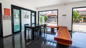 Un interior moderno con un banco de madera, una mesa negra y sillas.