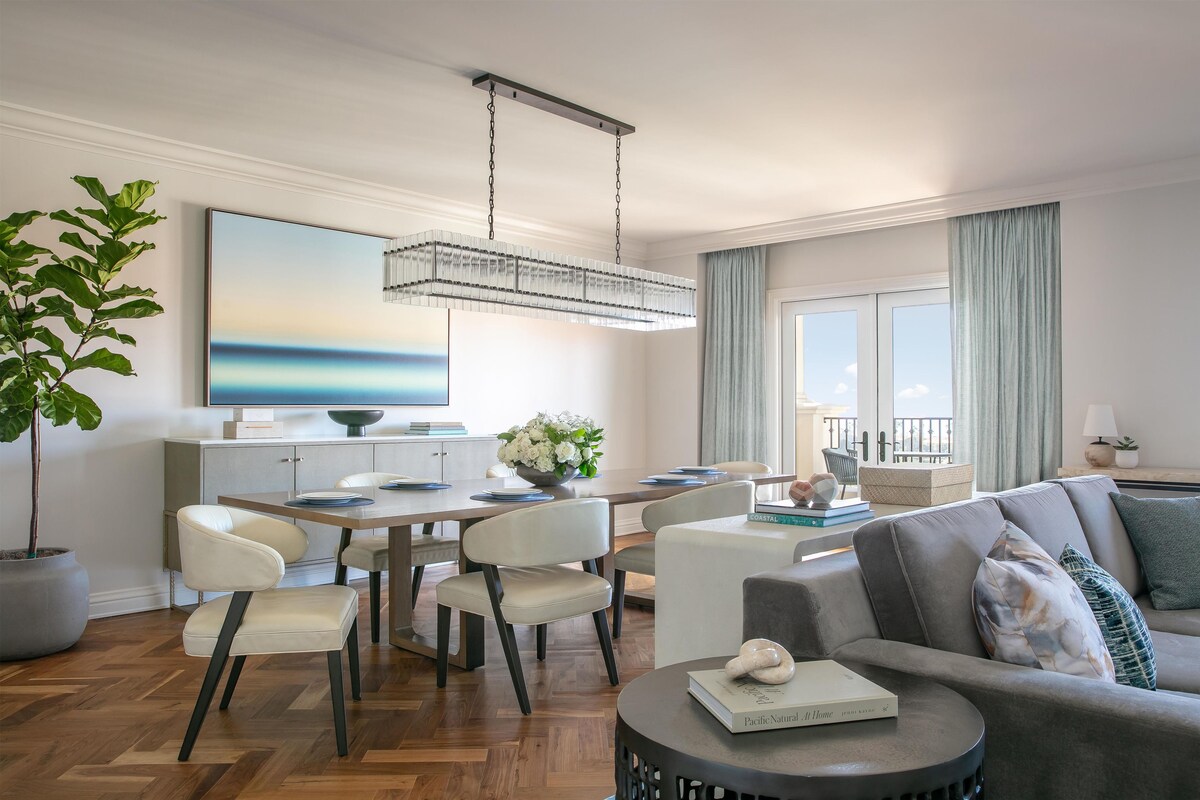 Ein modernes Wohnzimmer mit Essbereich, einem großen Gemälde und Blick ins Freie.