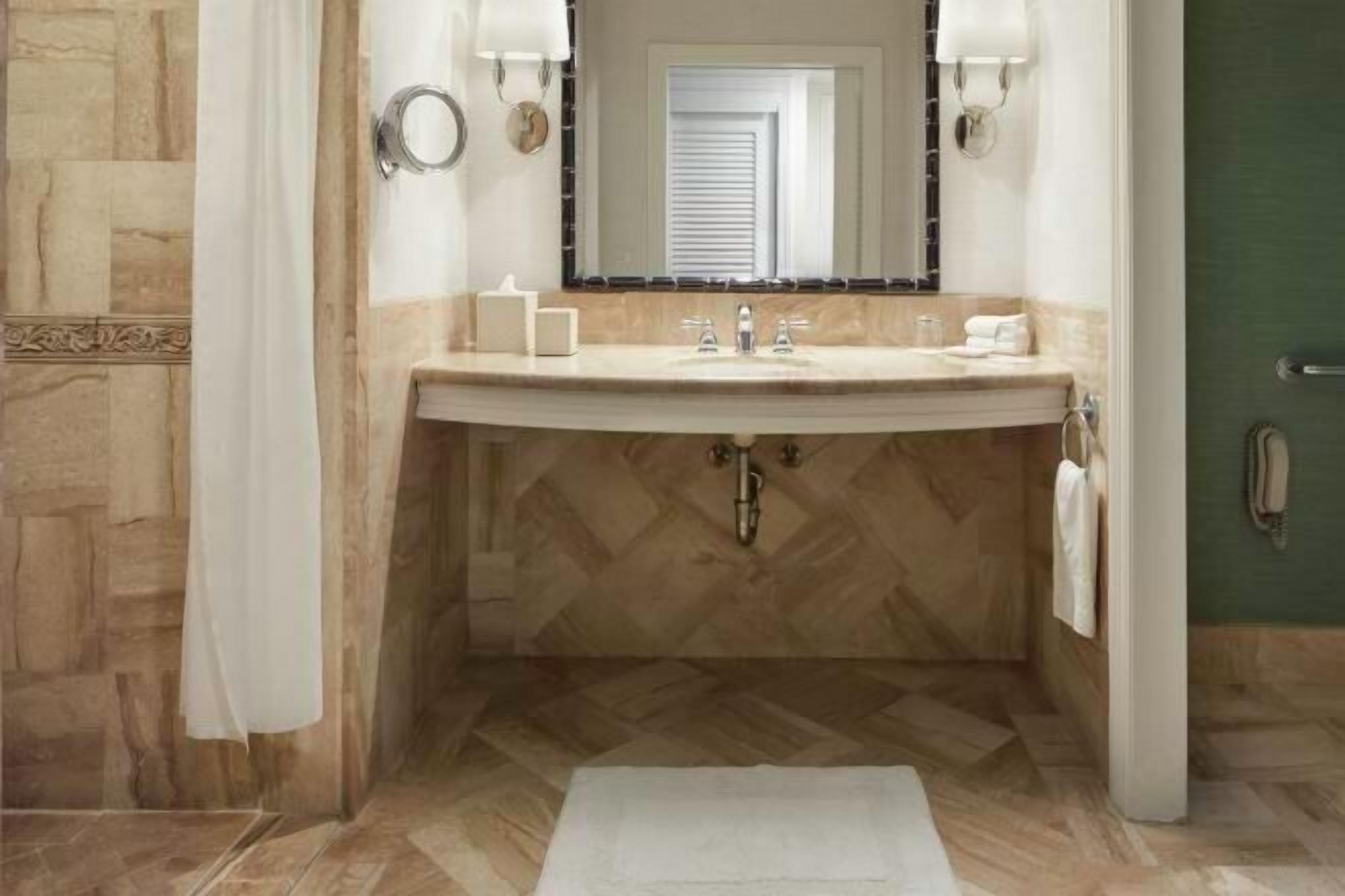 Een aparte badkuip en douche, een diep bad, designer toiletartikelen