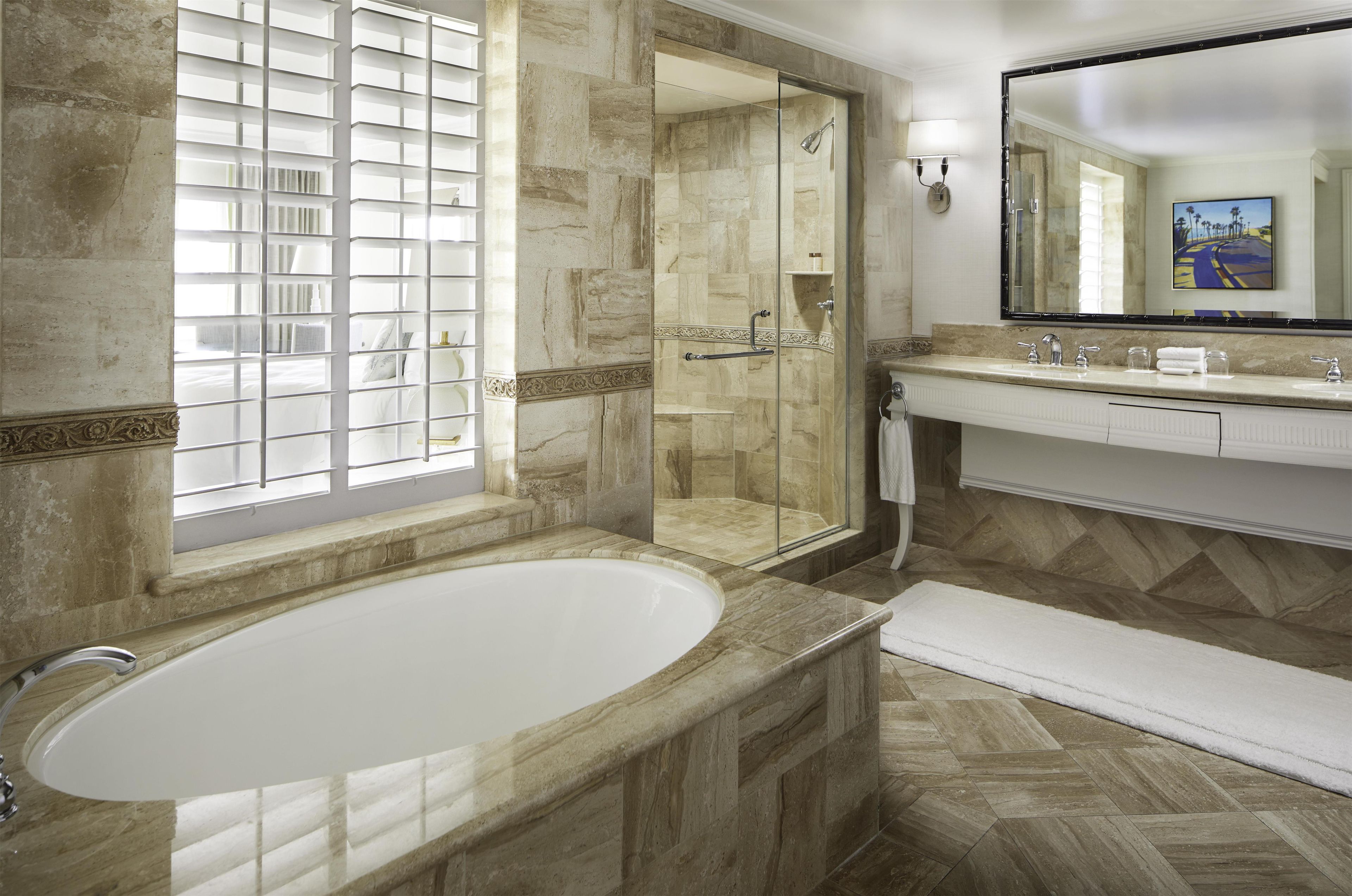A modern bathroom with a freestanding bathtub, a glass-enclosed shower, and a vanity with a large mirror.
