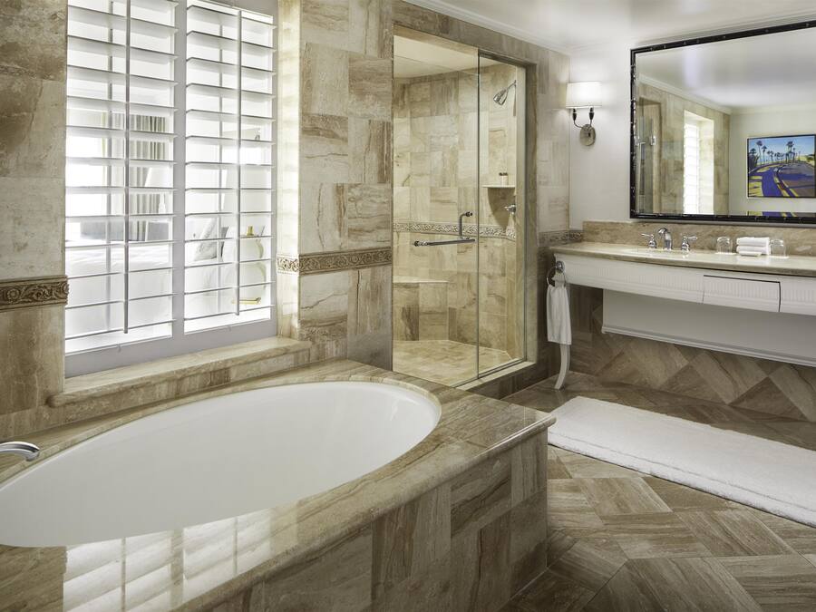 A modern bathroom with a freestanding bathtub, a glass-enclosed shower, and a vanity with a large mirror.