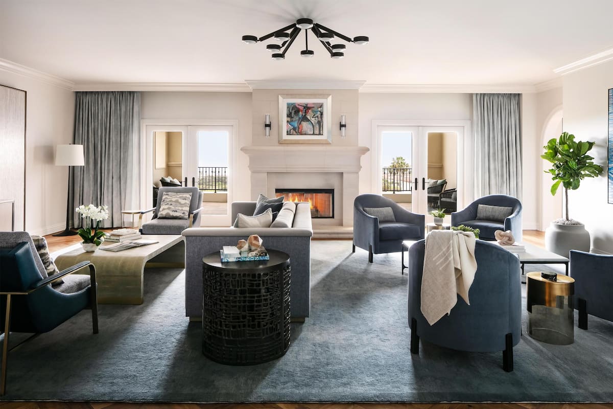 Un salón amplio con chimenea, muebles modernos y ventanas grandes.