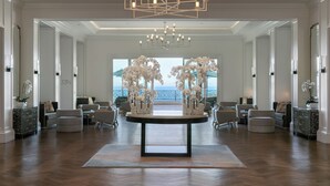 Un hall d’entrée spacieux, doté d’une table centrale, de plusieurs assises et d’un grand lustre.