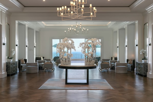 Un hall d’entrée spacieux, doté d’une table centrale, de plusieurs assises et d’un grand lustre.